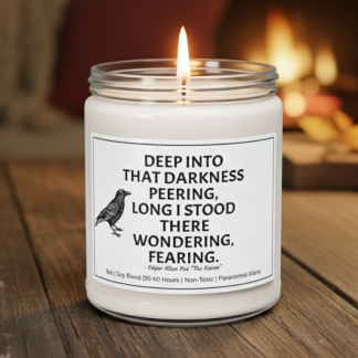 A white candle with a black lid sits on a wooden table. Its label features a raven and a quote from Edgar Allan Poe, creating a mysterious and cozy ambiance.