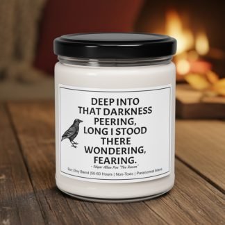 A white candle with a black lid sits on a wooden table. Its label features a raven and a quote from Edgar Allan Poe, creating a mysterious and cozy ambiance.