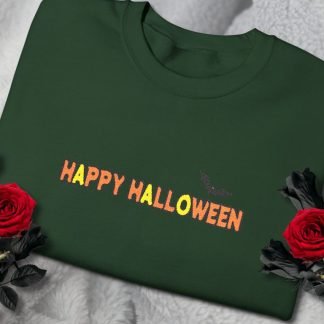 Dark green sweatshirt with "Happy Halloween" text in orange and yellow gradient, and a small black bat. Surrounded by red roses on white fabric.