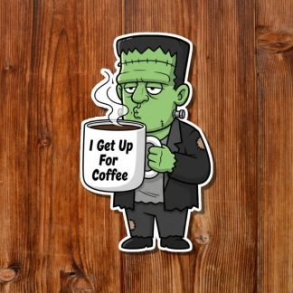 Cartoon of Frankenstein's monster with stitched forehead, holding a steaming mug labeled "I Get Up For Coffee." It looks sleepy on a wooden background.