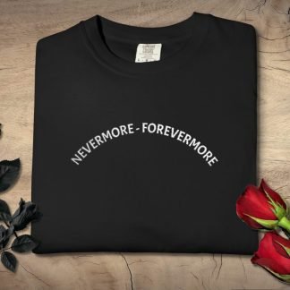 Folded black T-shirt with "NEVERMORE - FOREVERMORE" text in white. Surrounded by black roses on the left and red roses on the right on a wooden surface.