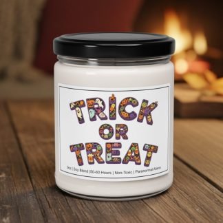 A "Trick or Treat" candle with a colorful label rests on a wooden table. The cozy, warm background shows a blurred fireplace, creating a festive, Halloween ambiance.