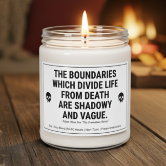 A white candle in a glass jar with a black lid sits on a wooden table. The label reads, "The boundaries which divide life from death are shadowy and vague" with a skull icon. A warm, blurred fireplace is in the background.